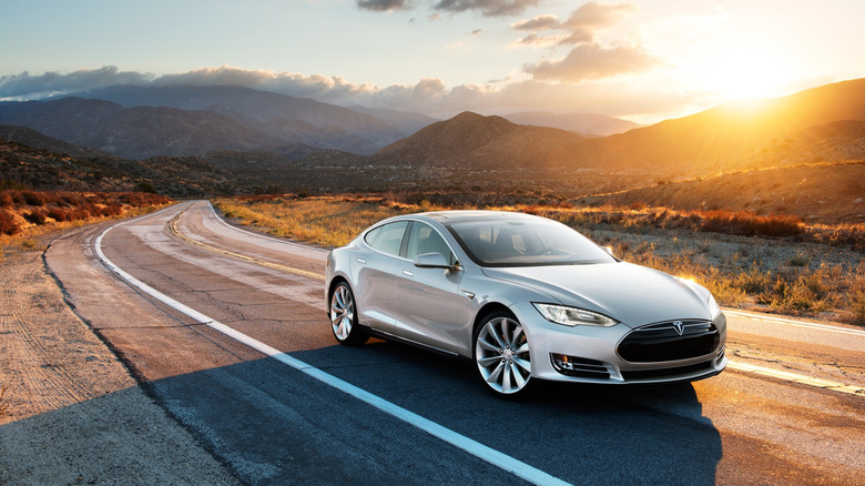 A Tesla Model 3 driving down an open road