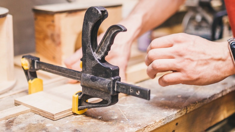 A bar-type speed clamp is being used to hold a woodworking project.