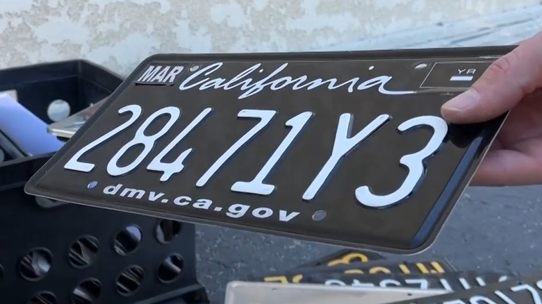 Hand holding a wrapped California license plate