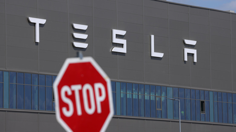 Stop sign in front of a Tesla building