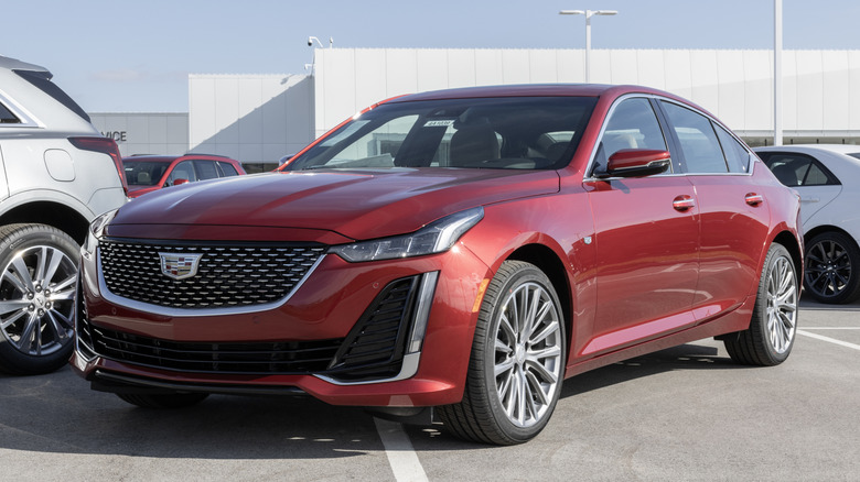 Front 3/4 view of red Cadillac CT5 parked on dealer lot.