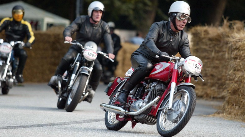 A trio of people racing classic cafe racers