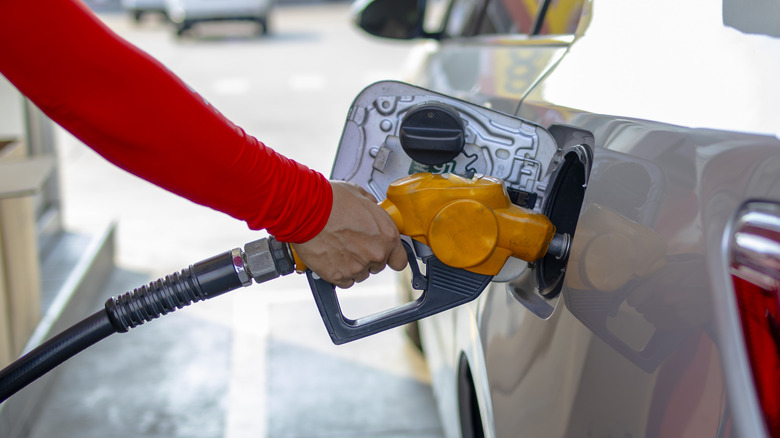 Person filling up a car with gasoline
