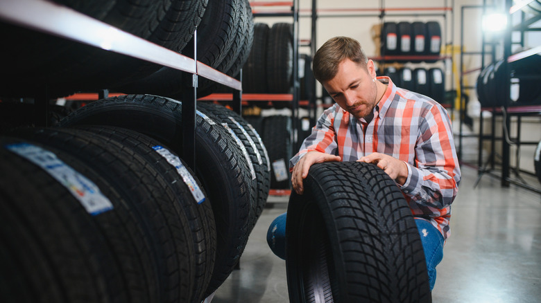 A person looking over a new tire.