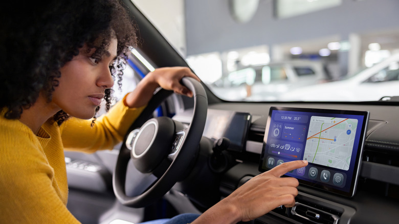 A driver looking at the dashboard and using the GPS system