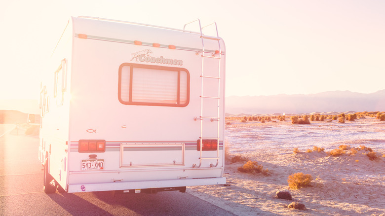 Sunlight shining on an RV parked near a desert landscape