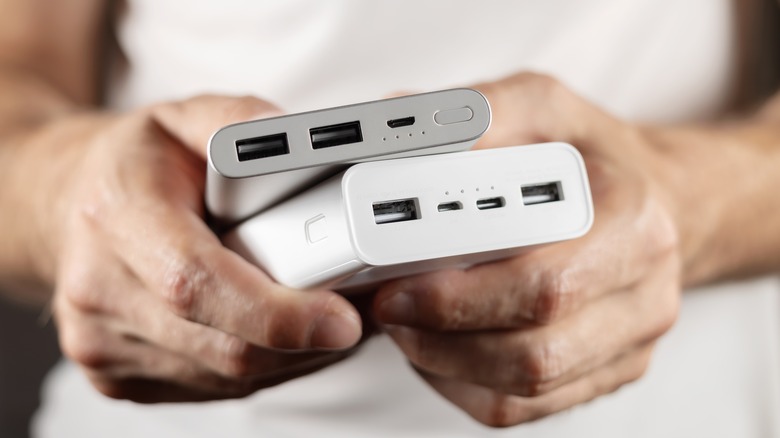 A man holding two powerbanks
