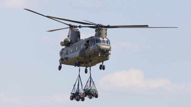 A CH-47 Chinook helicopter carrying two vehicles