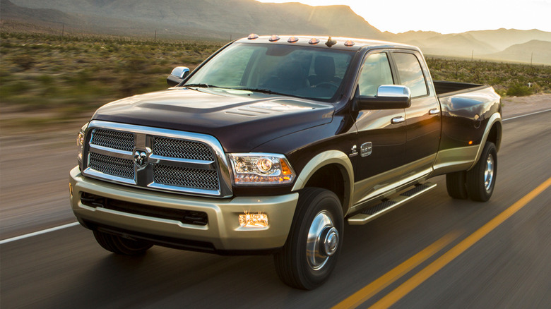 Black Dodge Ram truck driving down a desert road