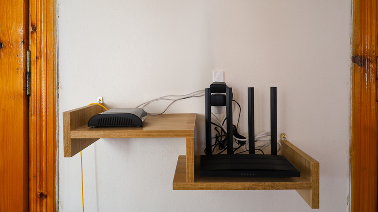 A standard wi-fi router installed on a wooden shelf