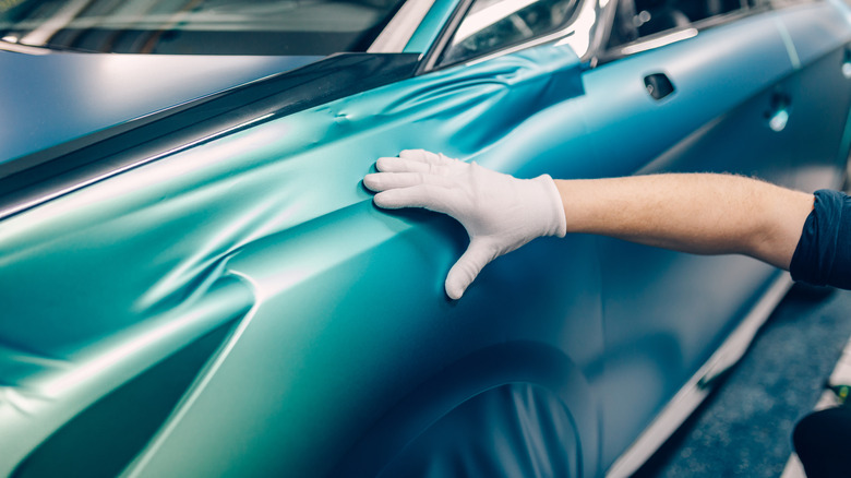 Car wrapping specialist putting vinyl foil or film on car
