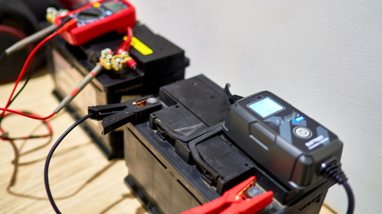 Two car batteries charging with cables
