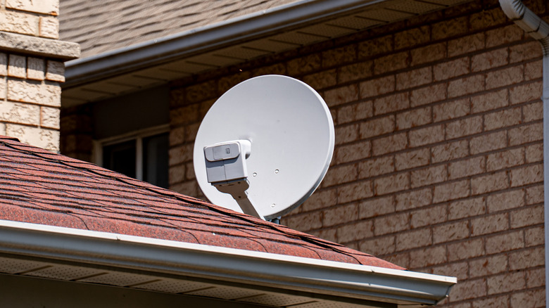 Close up of satellite dish on suburban house roof