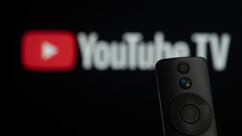 Smart TV remote in front of the YouTube TV logo displayed on a Smart TV.