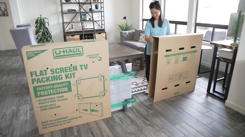 A person packing the TV in box