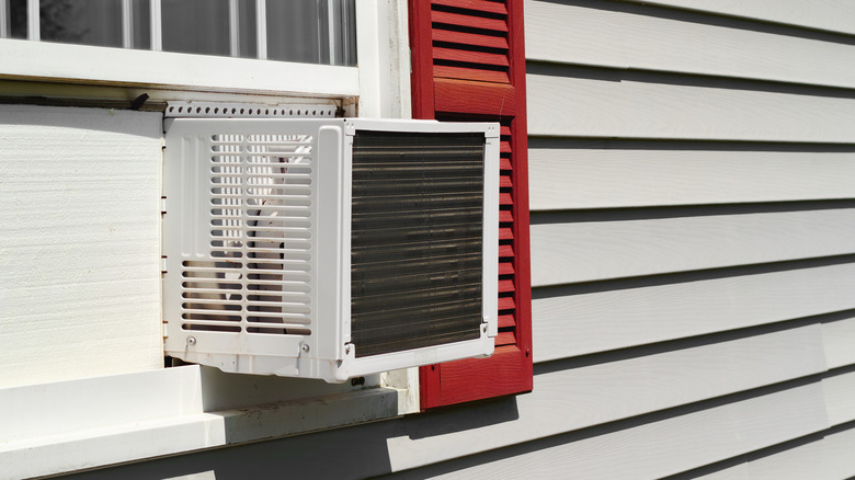 Window air conditioner installed in house window.