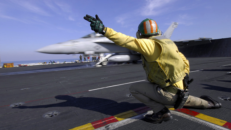 F-18 jet taking off from an aircraft carrier