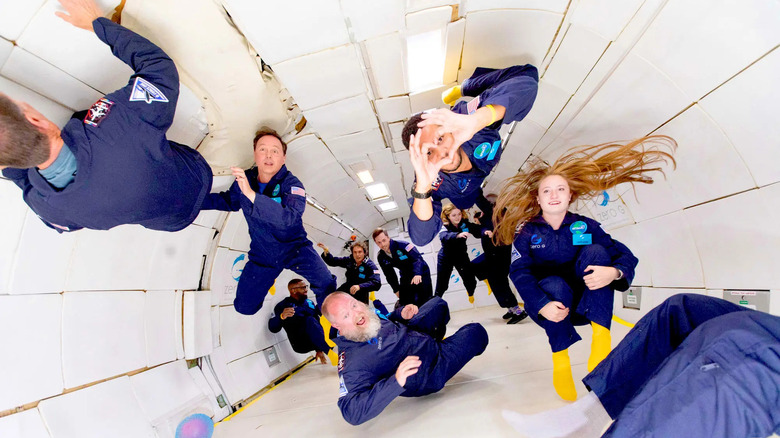 People floating in zero gravity inside a Zero-G plane flight.