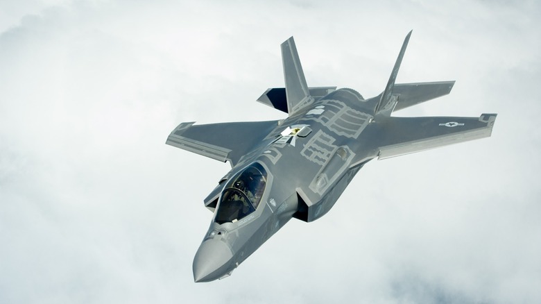 An F-35A Lightning II flying over clouds