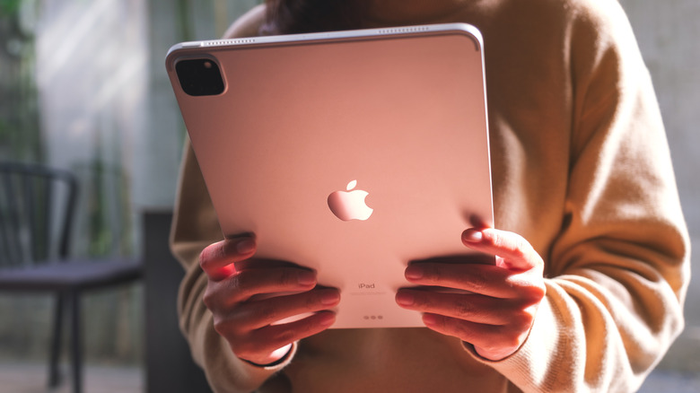 A woman holding and using Apple New iPad Pro digital tablet.