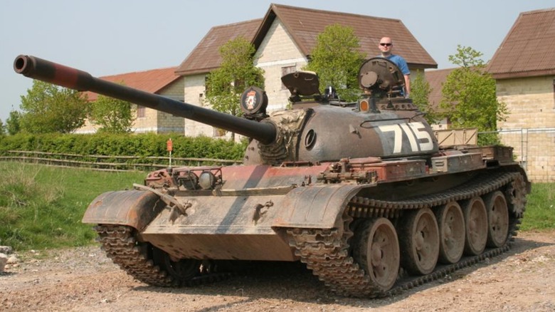 A civilian standing in the hatch of a Soviet T-55 Main Battle Tank
