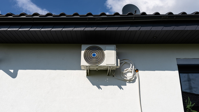 Air conditioning unit mounted to an exterior wall