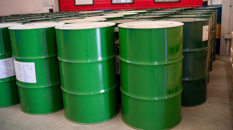 Green and white fuel barrels upright in warehouse