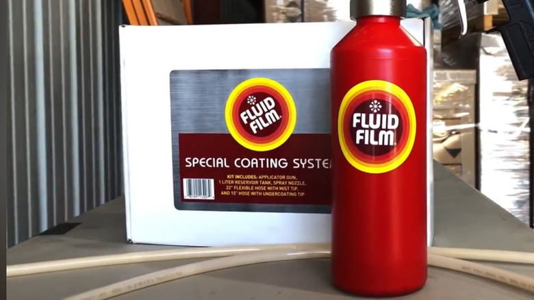 A canister of Fluid Film set in front of a packaged applicator kit