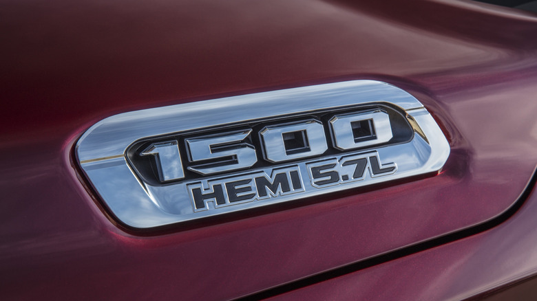 A 5.7L HEMI engine badge on a red Ram 1500 pickup