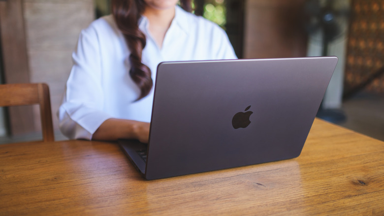 Woman working on MacBook on table