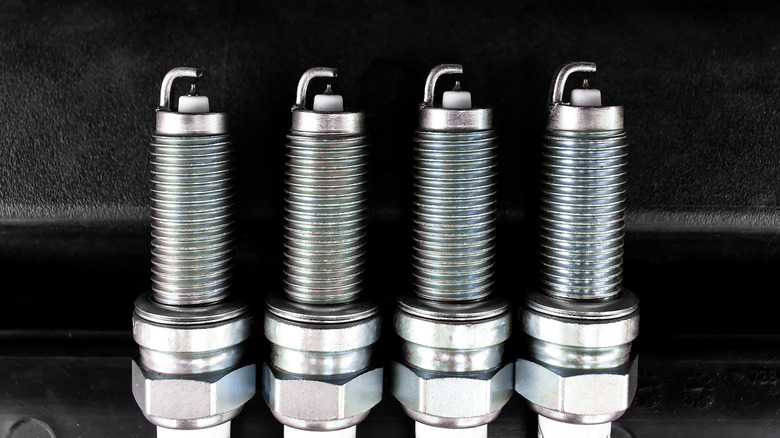 A close-up of four iridium-tipped car spark plugs