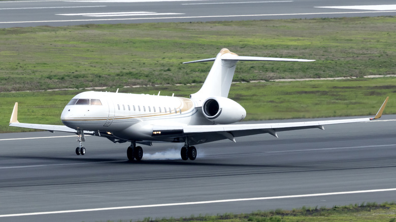 A private jet landing on airport tarmac.