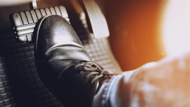 Man's foot holding down on car brake