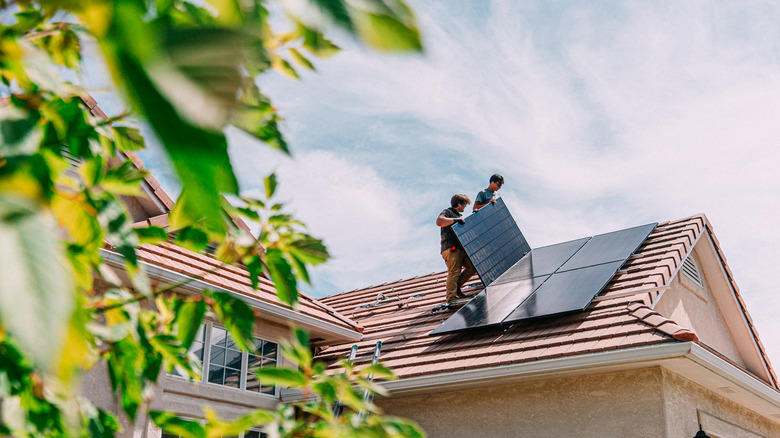 Men installing solar panels on roof