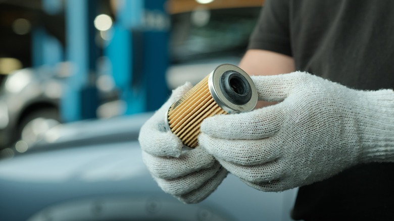 Mechanic holding oil filter