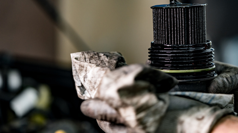 Dirty oil filter in repairman's hand