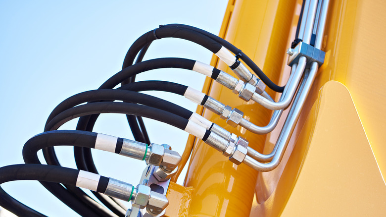 Hydraulic lines on construction equipment showing metal piping and high-pressure hoses