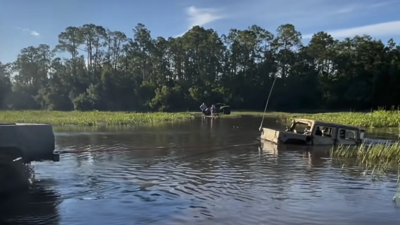 a flooded diesel humvee is pulled out of the water