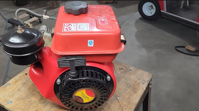 Red 168F diesel engine on a wooden stand
