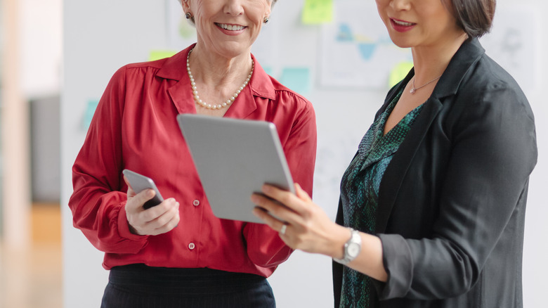 two women looking at tablet screen