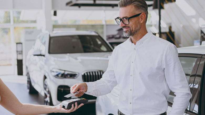 Man paying for a car with a credit card