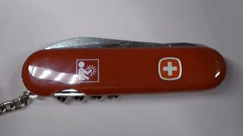 A vintage left-handed Wenger Swiss Army Knife. On the scale, it shows the traditional Swiss flag and also a pictogram of a person raising their left arm with rays coming from their left hand. This was the symbol used on all left-handed Wenger Swiss Army Knives.