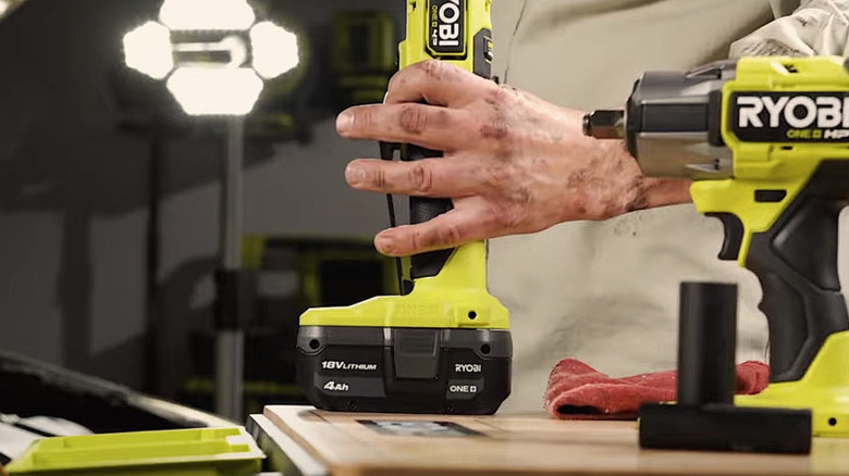 Person using Ryobi tool with 18V battery pack