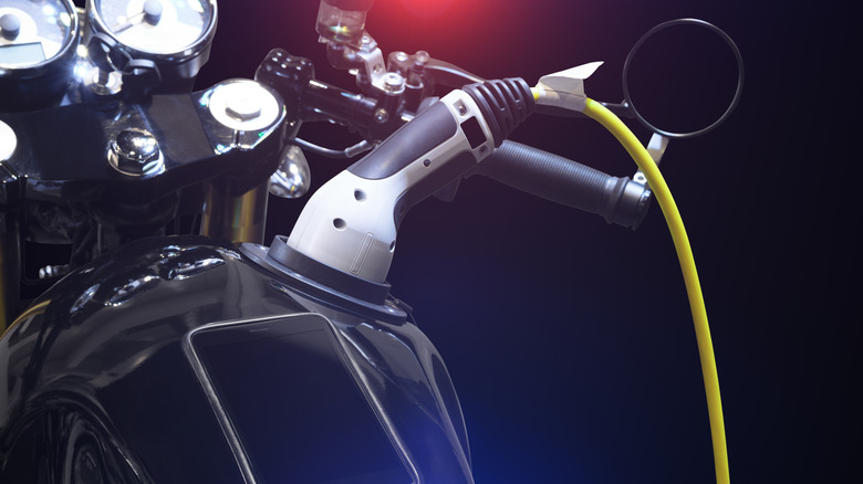 A black electric motorcycle charging at an EV station