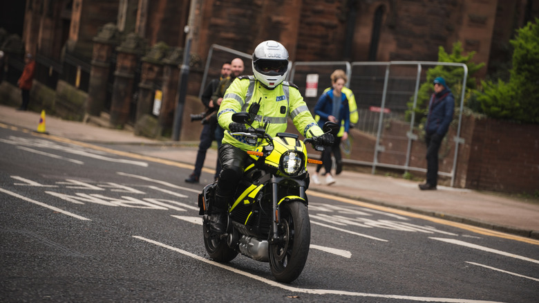 A police officer riding a LiveWire motorcycle, front 3/4 view