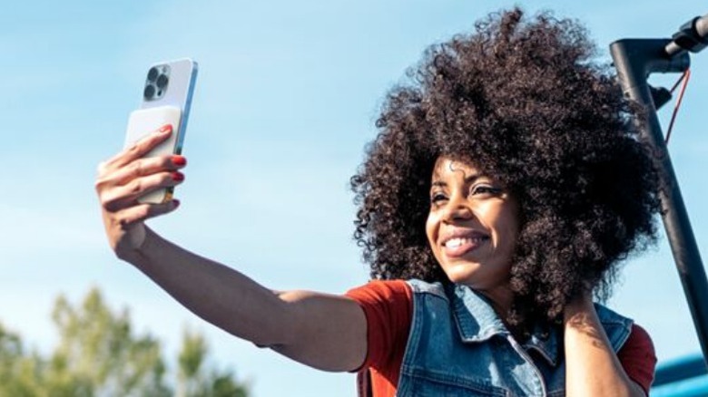 Woman taking selfie with Belkin power brick on phone