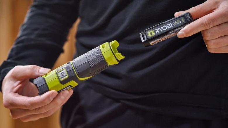 Person installing Ryobi USB Lithium battery in a USB Lithium tool