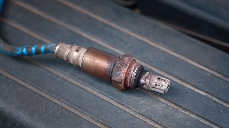 Close-up of dirty oxygen sensor removed from car