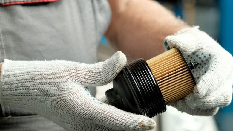 a person replacing the filter for a car's cannister-style oil filter