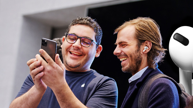 One man holding iPhone and another man using AirPods